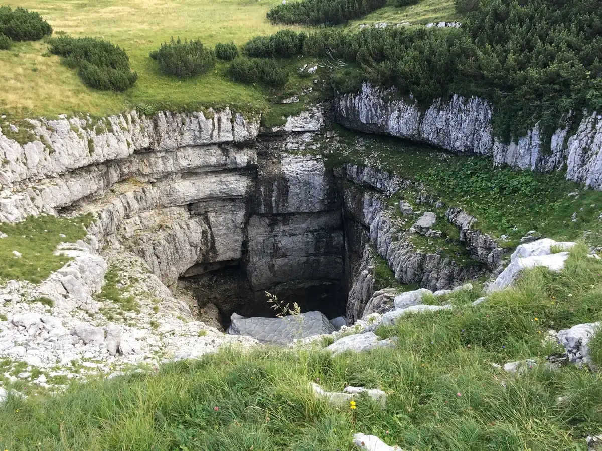 Puits naturel souterrain avec cascade d'eau dans une grotte calcaire