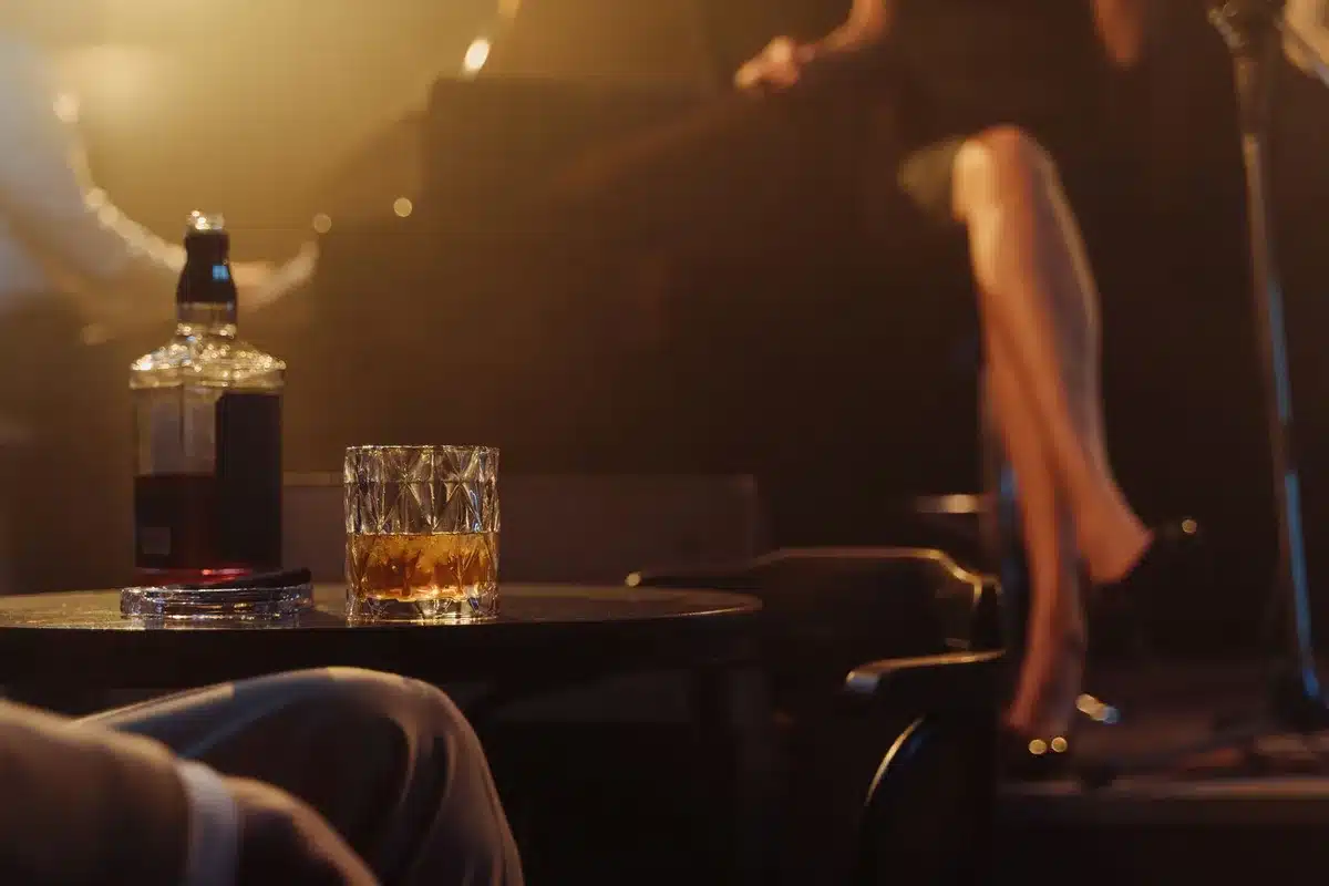 Barman préparant un cocktail dans une ambiance chaleureuse et intime