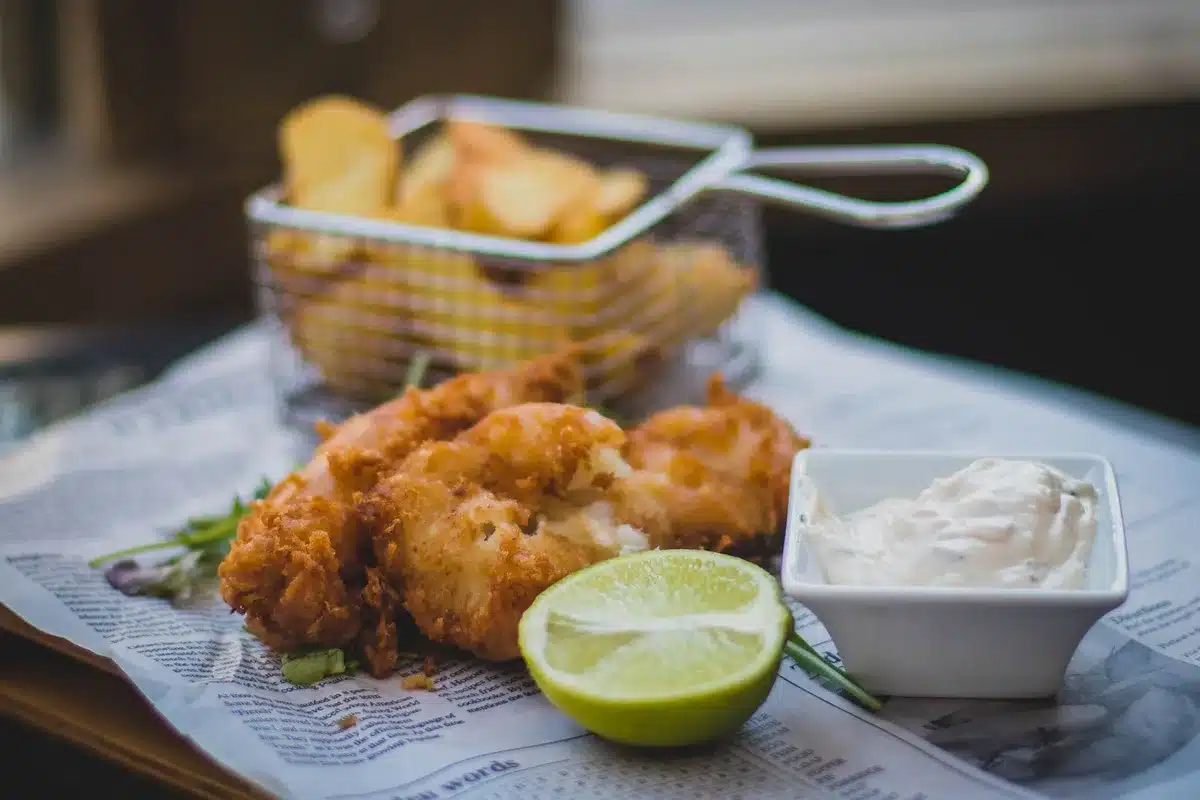 Fish and chips servi dans du papier journal traditionnel avec frites épaisses dorées