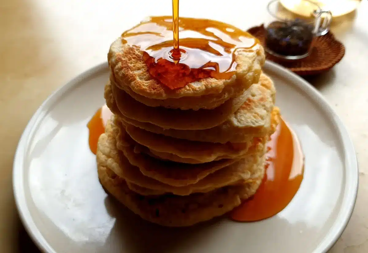 Pile de pancakes dorés nappés de sirop d'érable doré