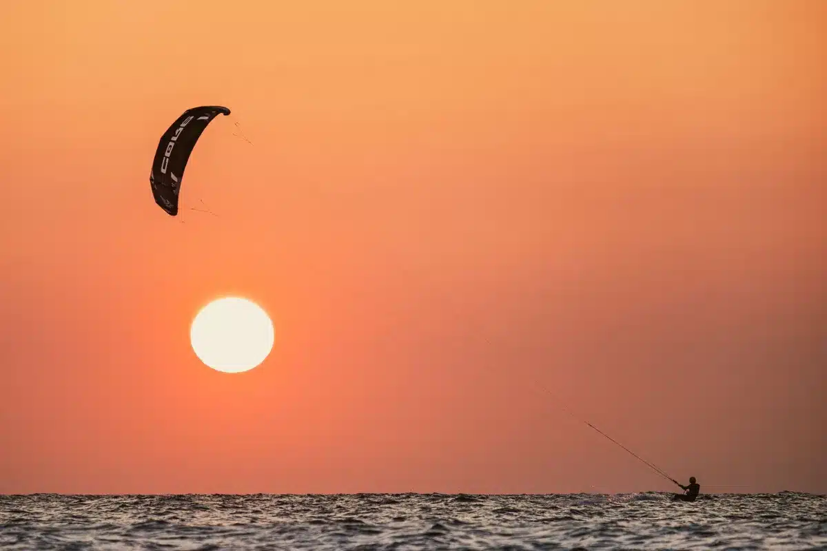 Plage de Dubaï avec baigneurs et sports nautiques au coucher du soleil