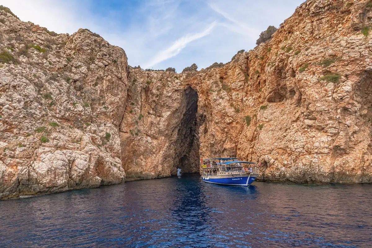 Grotte marine aux eaux turquoise intense accédée par bateau
