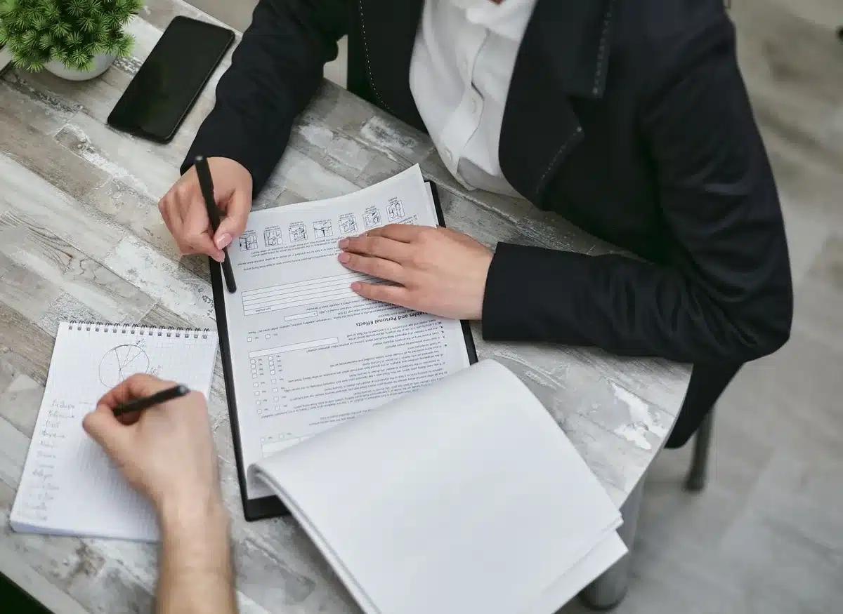 Documents et liste de contrôle pour préparer un voyage, étalés sur un bureau