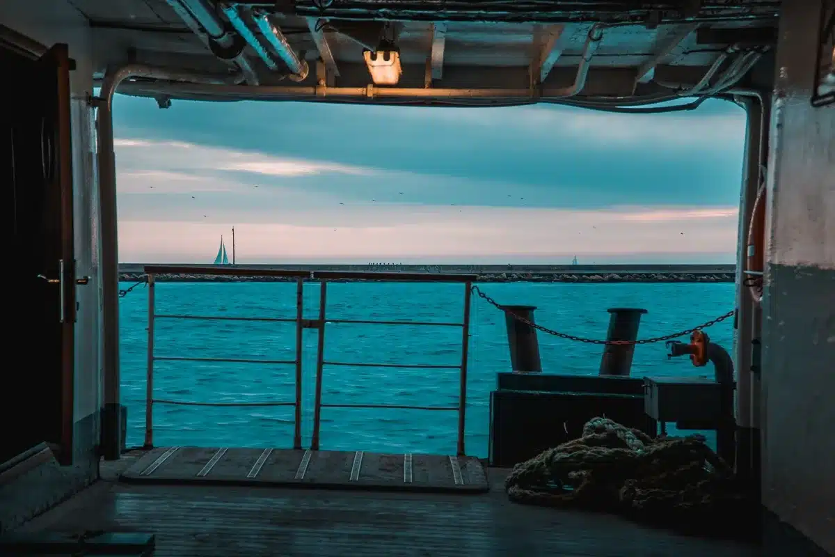 Passager sur le pont d'un navire de croisière moderne face à l'horizon marin au crépuscule