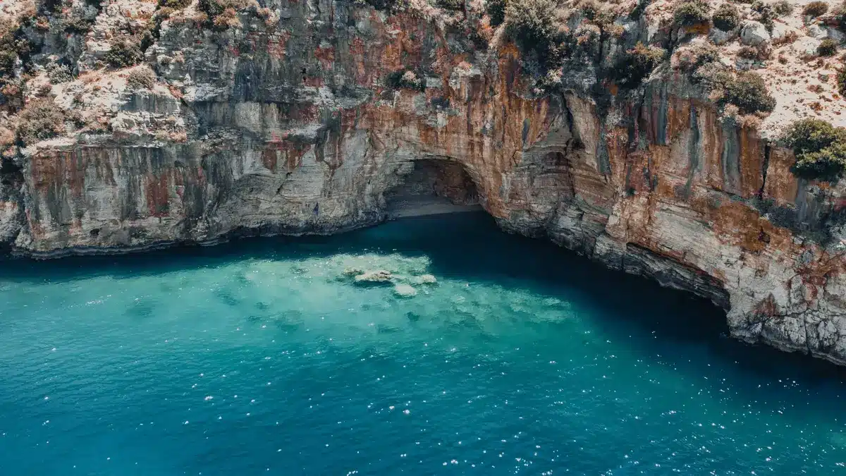 Petite crique turquoise isolée entre les rochers, accessible après une courte marche