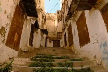 Ruelle étroite de médina avec architecture traditionnelle marocaine et passants anonymes