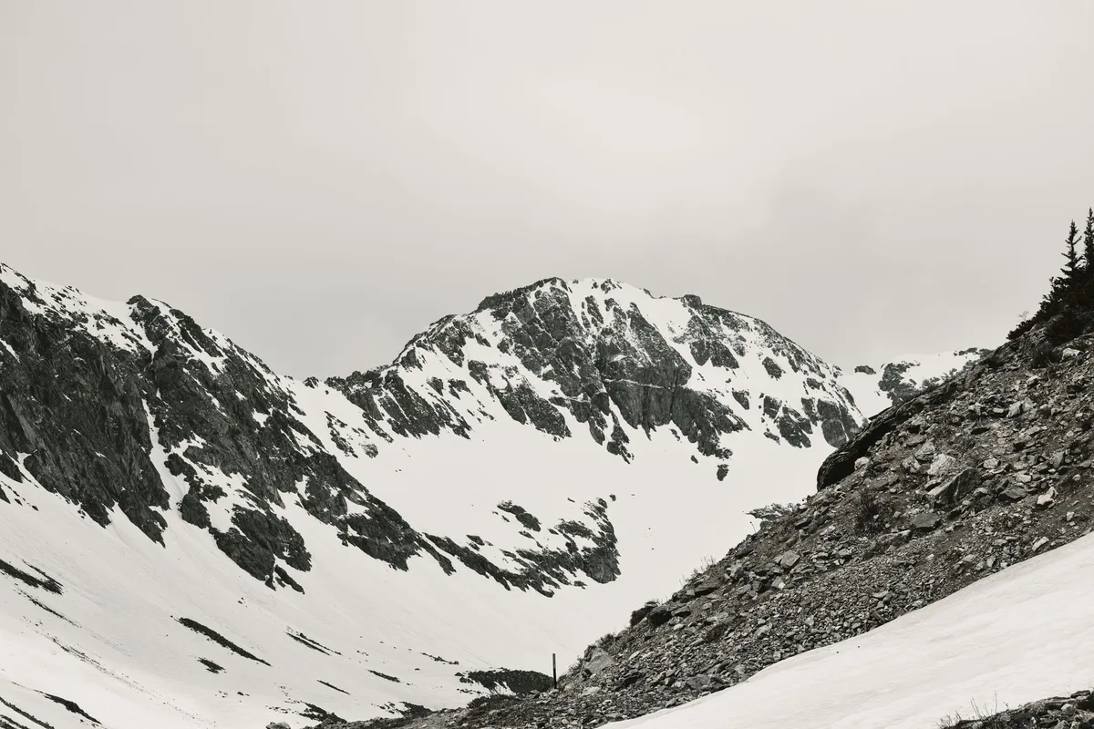 Randonneur traversant un terrain rocheux exposé en haute montagne