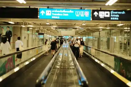 Voyageurs anonymes dans un terminal d'aéroport international, représentant les flux touristiques mondiaux.