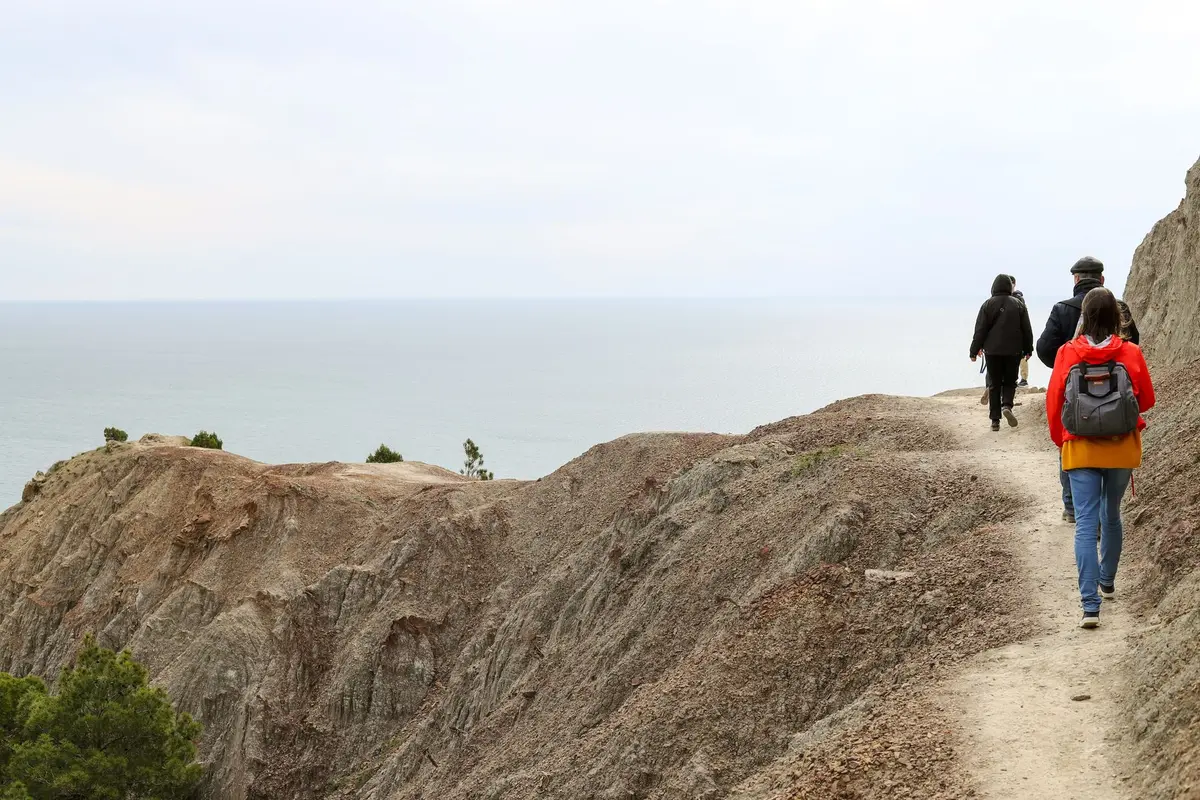 Sentier de randonnée longeant des falaises rocheuses surplombant la mer
