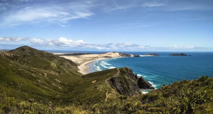 Randonneur solitaire face à des falaises côtières et des dunes, vue panoramique sur la mer