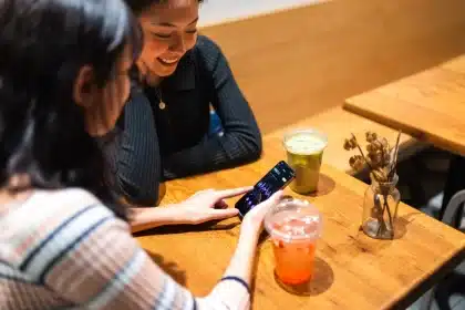 Voyageur consultant une application de voyage personnalisée sur son téléphone en terrasse montréalaise