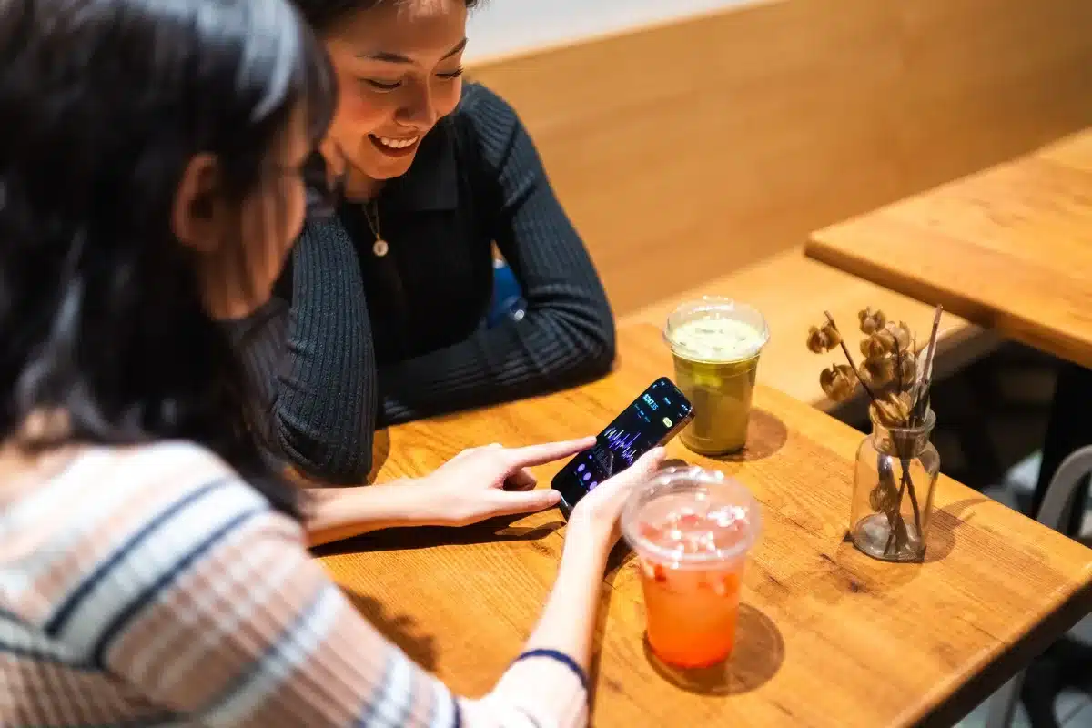 Voyageur consultant une application de voyage personnalisée sur son téléphone en terrasse montréalaise