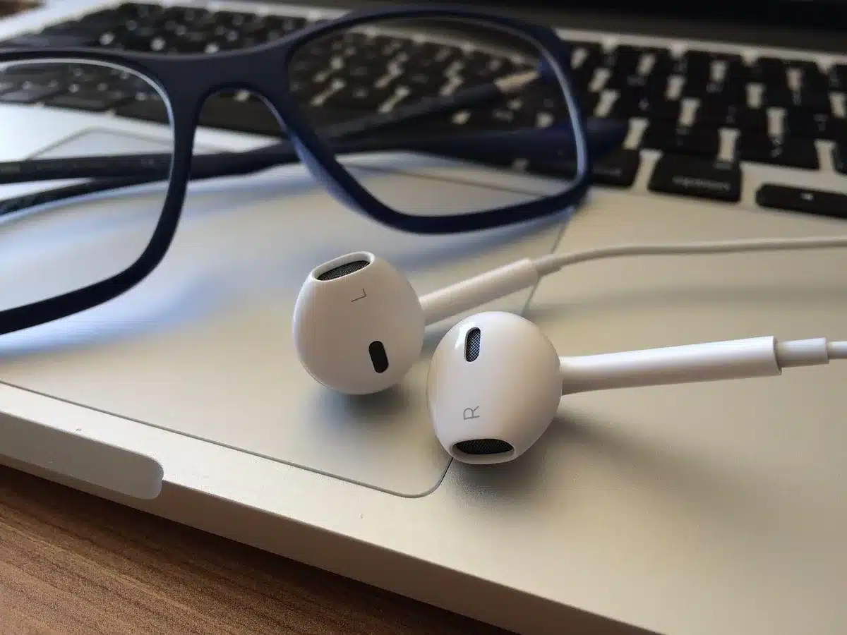 Quelqu'un écoutant un podcast ou une vidéo en anglais sur son téléphone avec des écouteurs