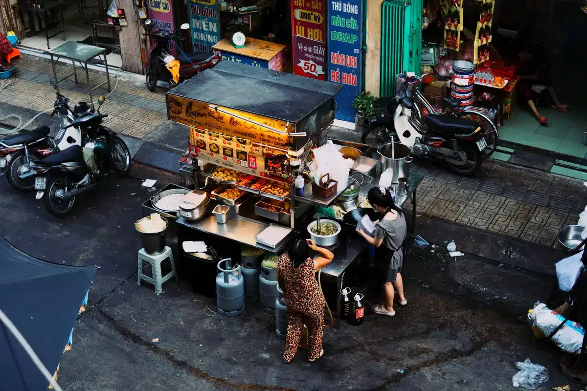 Vendeur préparant de la street food dans un marché de rue asiatique