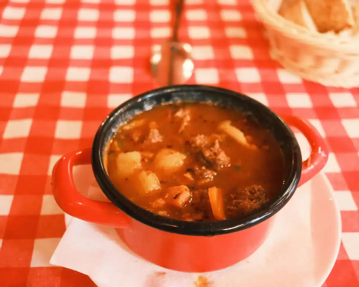Bol de goulash hongrois fumant avec viande et légumes, riche sauce rouge au paprika
