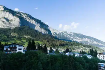 Vue depuis un balcon d'hôtel spa sur une vallée alpine en automne avec montagnes en arrière-plan