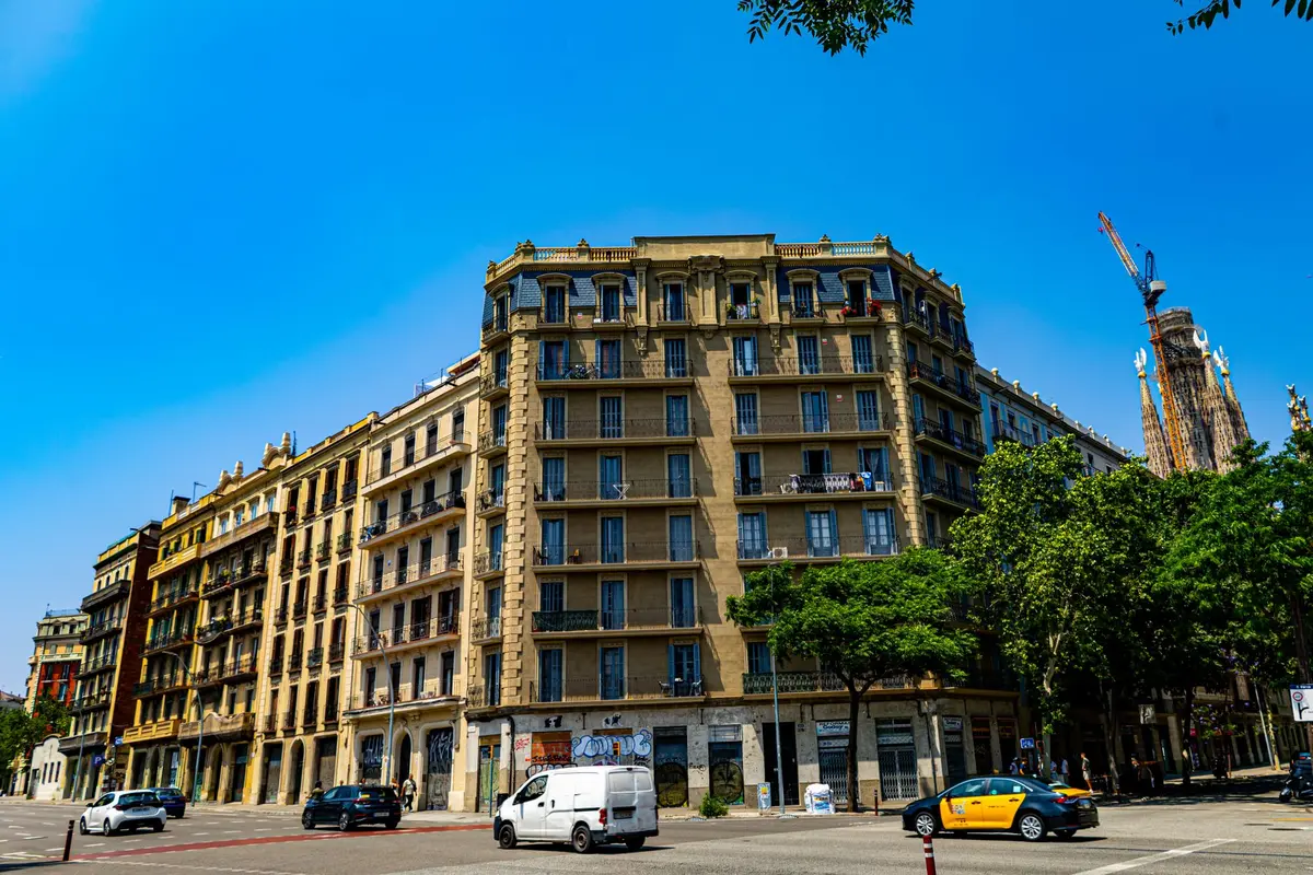 Famille marchant dans une avenue large et ensoleillée de Barcelone avec architecture moderniste