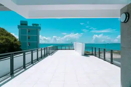 Terrasse d'un petit lodge côtier avec vue sur la mer, mobilier confortable et ambiance chaleureuse