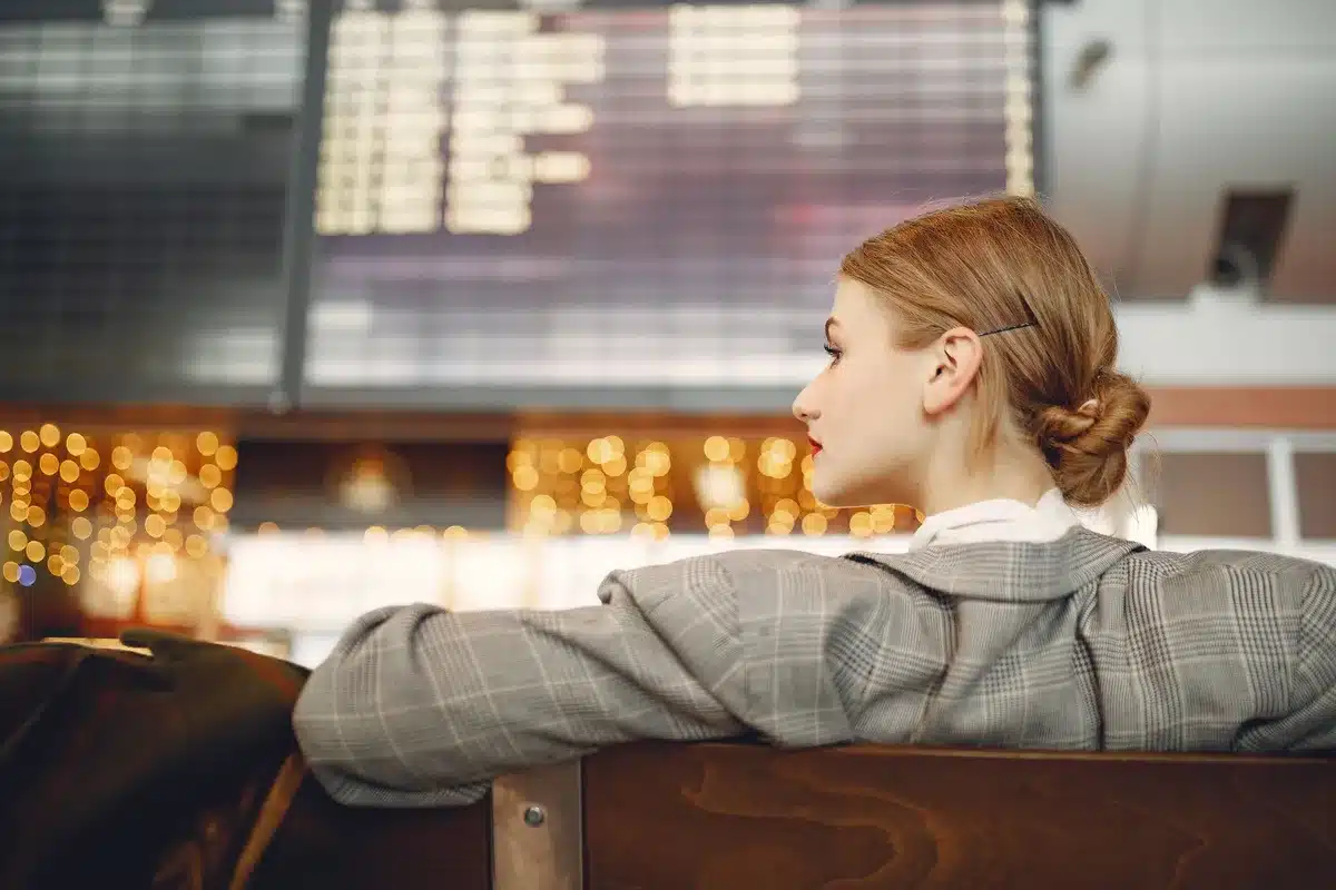 Voyageur consultant les options de vols sur un ordinateur portable au comptoir de l'aéroport