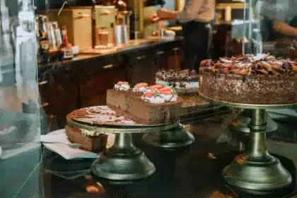 Vitrine de pâtisserie italienne avec tiramisu, cannoli et gâteaux colorés en lumière du jour