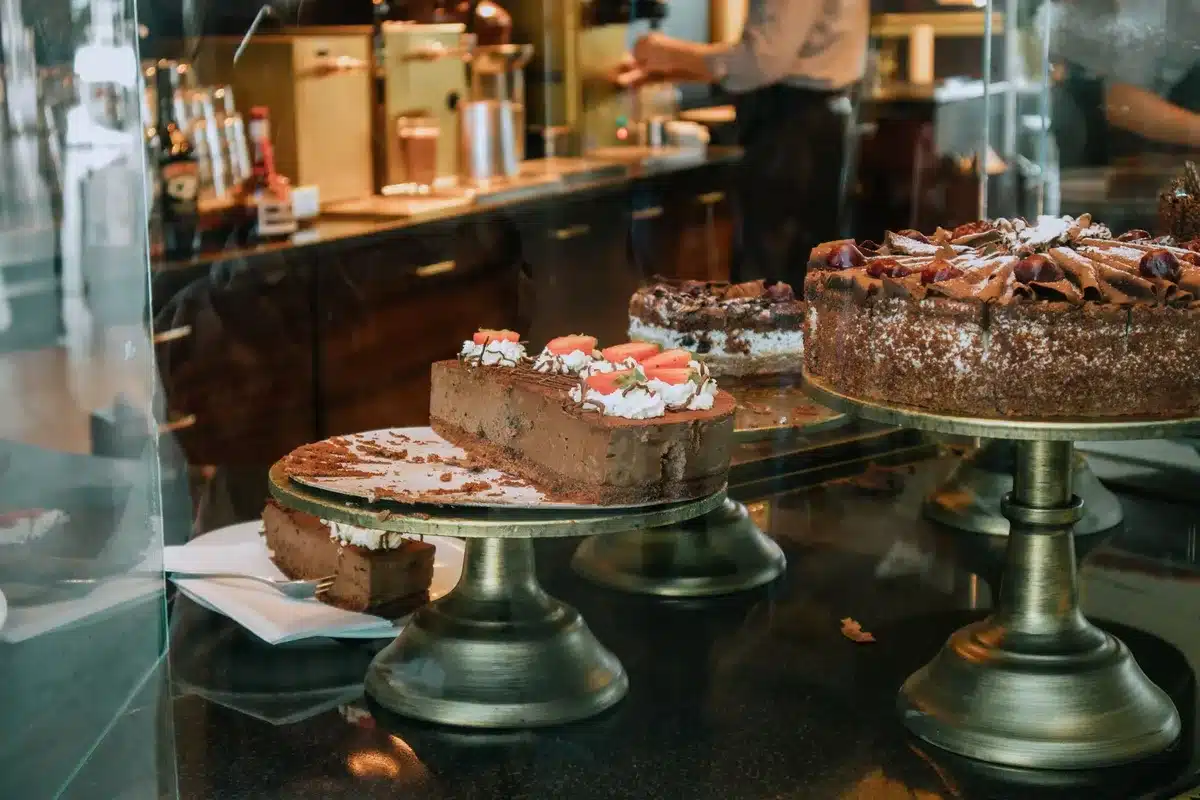 Vitrine de pâtisserie italienne avec tiramisu, cannoli et gâteaux colorés en lumière du jour