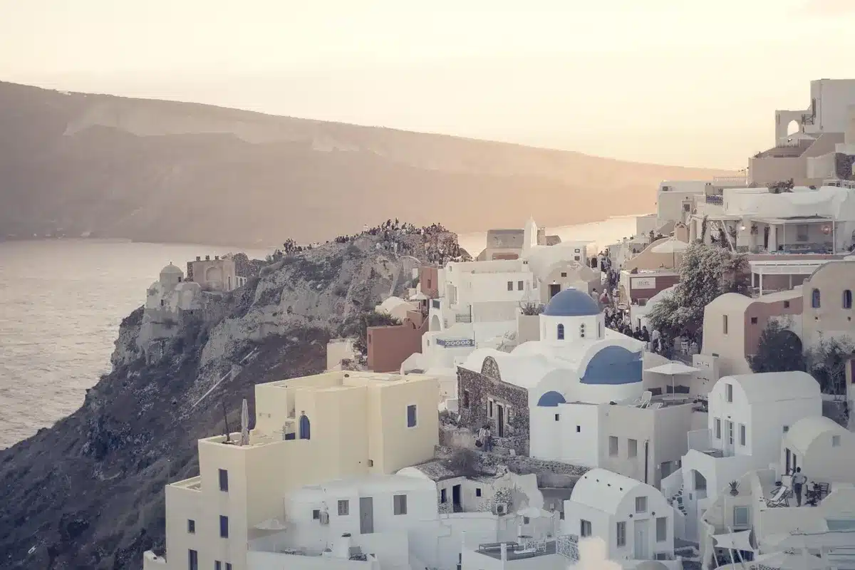 Voilier approchant une île des Cyclades avec maisons blanches