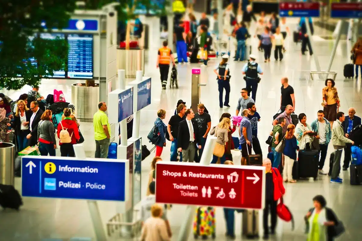 Panneau départs et voyageurs dans une gare aéroportuaire, vérification des horaires