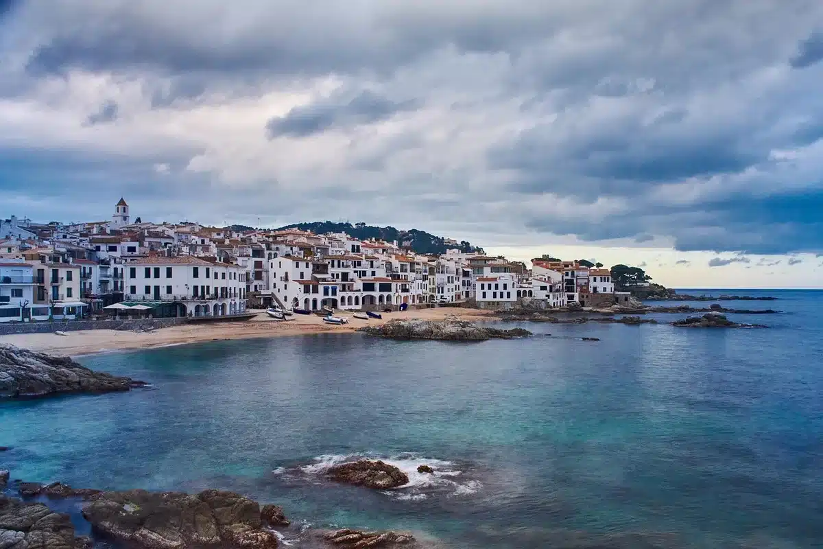 Vue aérienne d'une côte méditerranéenne ensoleillée avec plages et navires de croisière à l'horizon