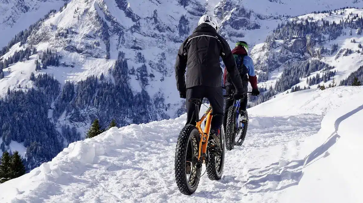 Cycliste sur fat bike électrique dans un sentier enneigé montagneux