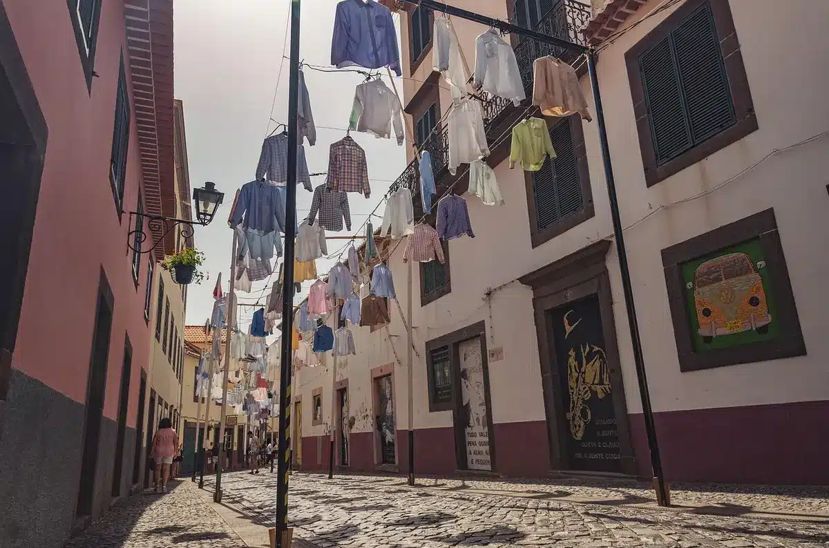 Rue médiévale pavée avec façades gothiques historiques et quelques passants anonymes sous la lumière dorée