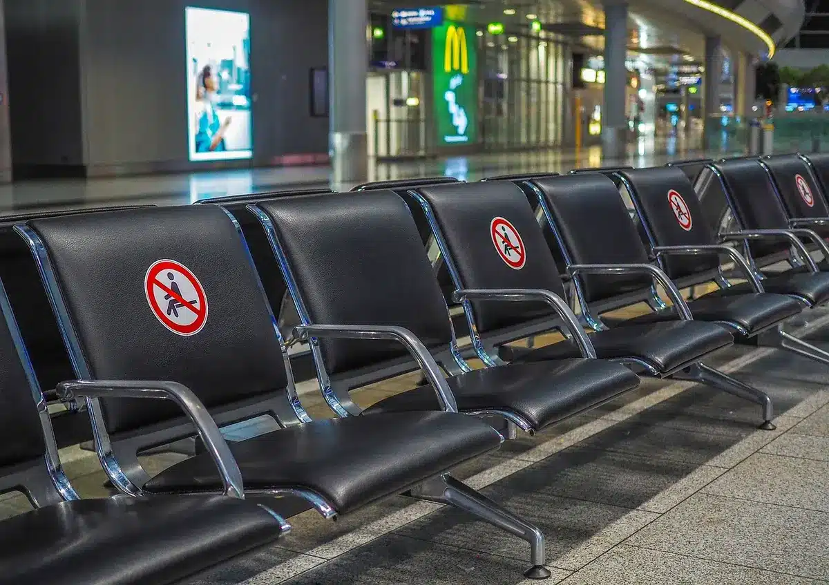 File d'avions sur le tarmac et écrans d'arrivée affichant nombreux vols