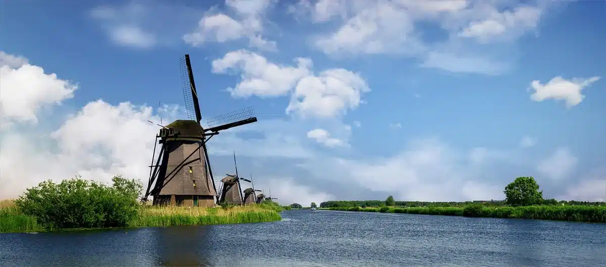 Rangée de moulins à vent traditionnels aux Pays-Bas reflétés dans l'eau, classés au patrimoine mondial