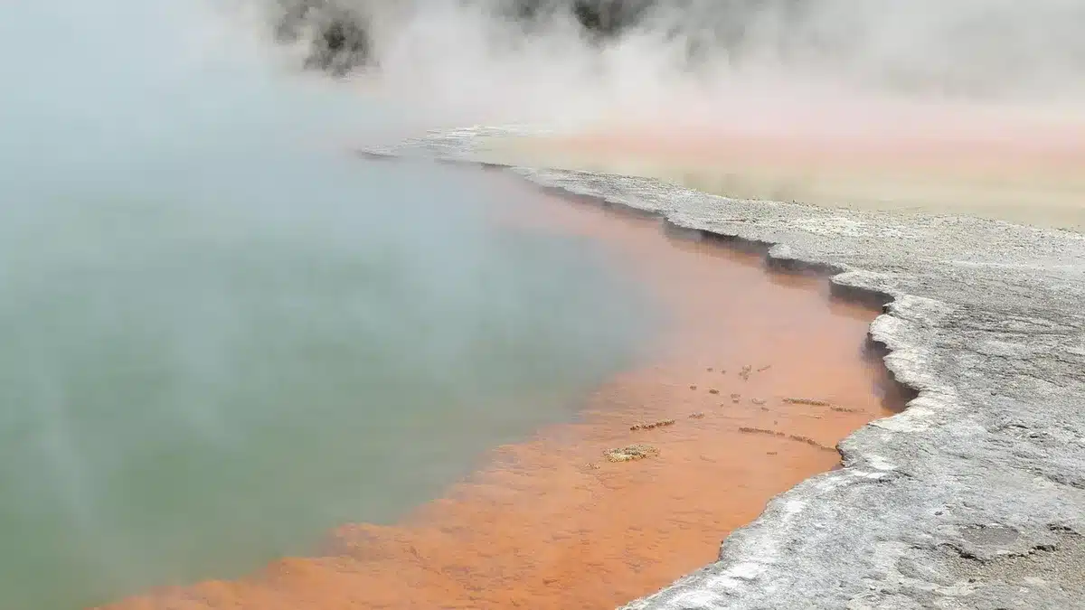 Piscine thermale extérieure en journée entourée de montagnes enneigées