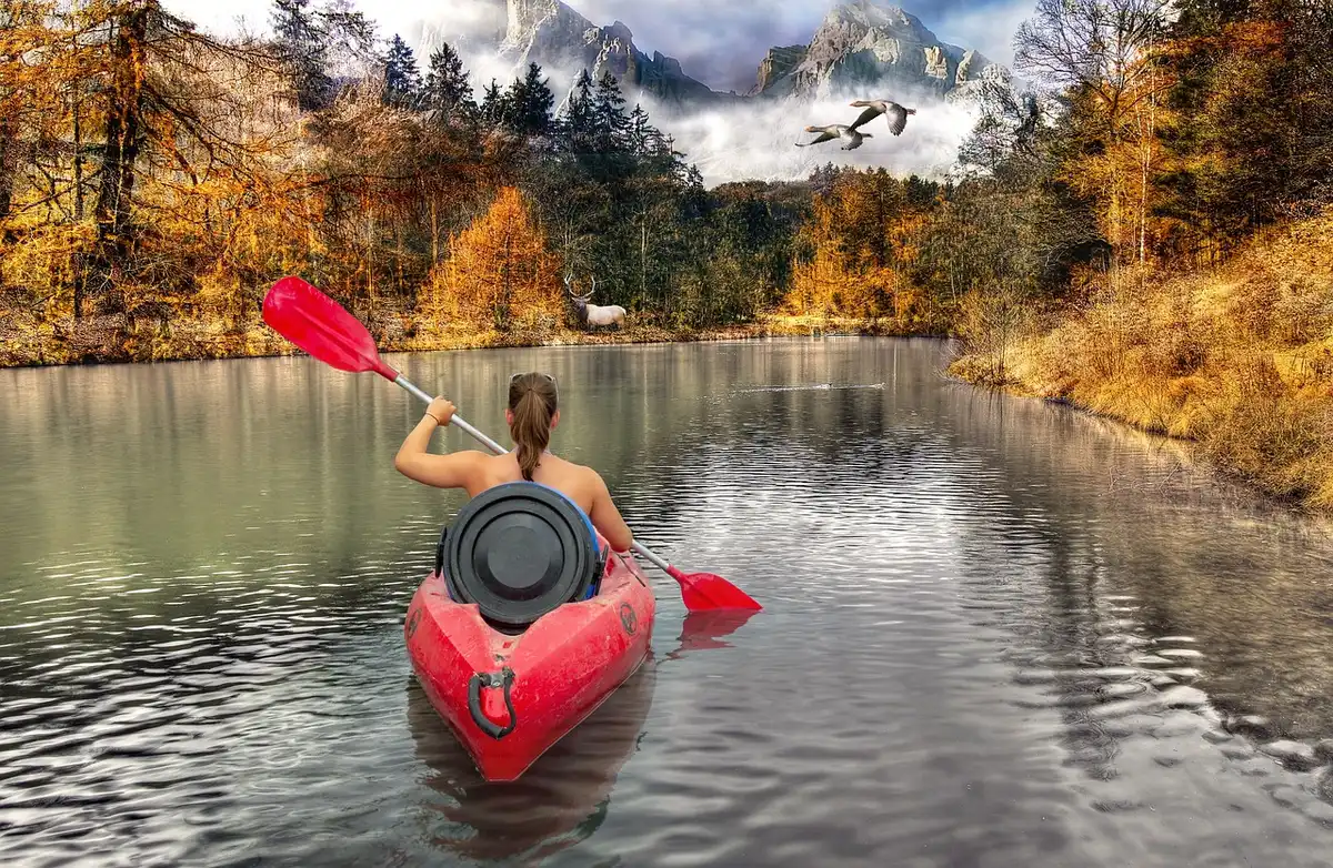 Couverture et thermos au bord d'un lac avec kayaks à proximité