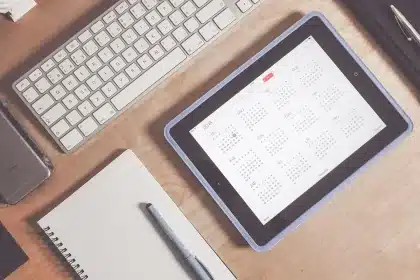 Table de préparation de voyage avec guide, smartphone et mains, fenêtre ensoleillée