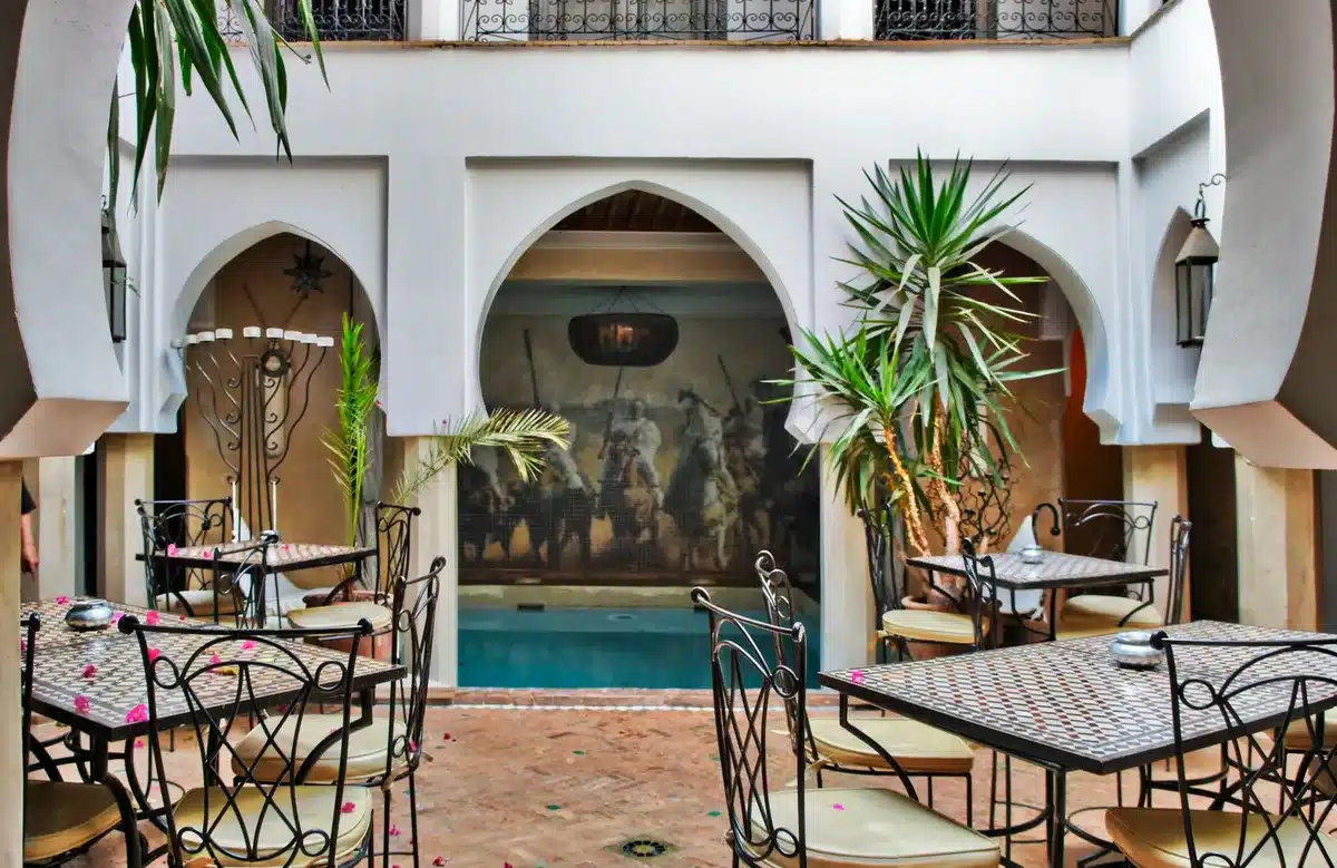 Patio intérieur d'un riad traditionnel avec plantes et bassin