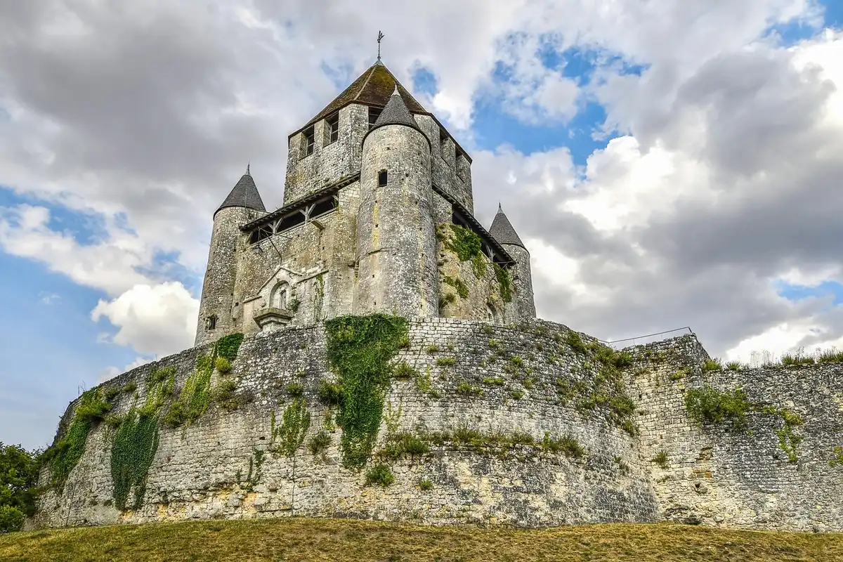 Sainte-Suzanne et ses remparts vus depuis un sentier ensoleillé