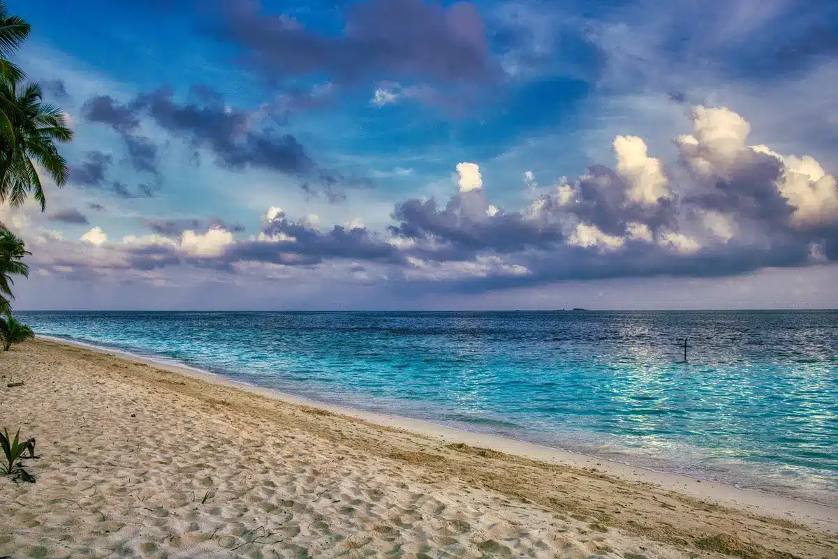 Chemin menant d'un hôtel à une plage de sable et eau turquoise